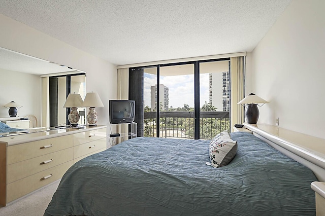 carpeted bedroom with floor to ceiling windows, a textured ceiling, and access to exterior