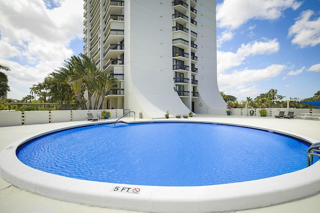 pool featuring fence and a patio area