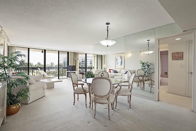dining area with carpet floors, a textured ceiling, and expansive windows