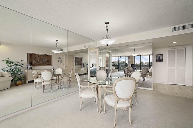 carpeted dining area featuring a textured ceiling and visible vents