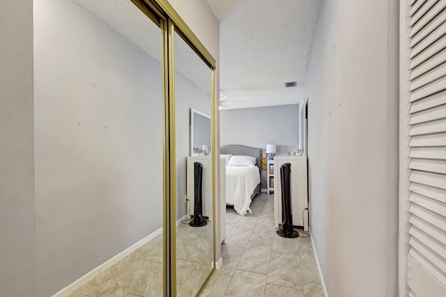 245 Bilbao St, Royal Palm Beach, FL 33411 - corridor featuring a textured ceiling, light marble finish floors, and baseboards