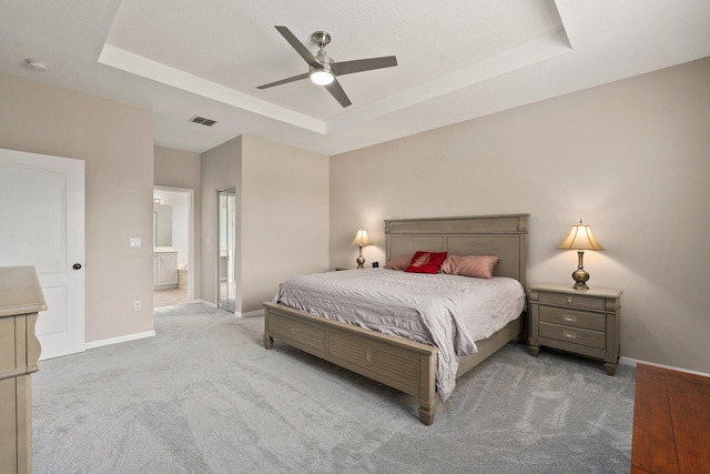 9943 SW Stonegate Dr, Port Saint Lucie, FL 34987 - bedroom with a raised ceiling, carpet, baseboards, and ensuite bath