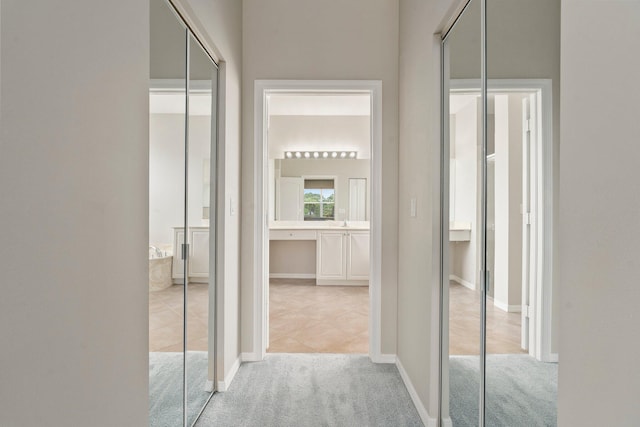 9943 SW Stonegate Dr, Port Saint Lucie, FL 34987 - hallway featuring carpet, baseboards, and tile patterned flooring