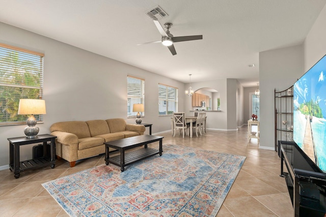 9943 SW Stonegate Dr, Port Saint Lucie, FL 34987 - living area featuring ceiling fan, light tile patterned floors, arched walkways, and baseboards