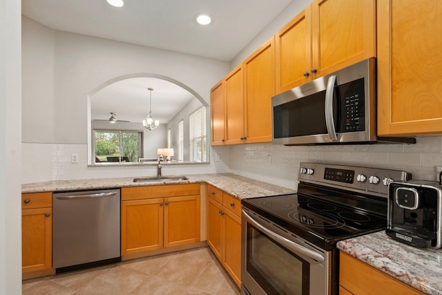 9943 SW Stonegate Dr, Port Saint Lucie, FL 34987 - kitchen with appliances with stainless steel finishes, a sink, backsplash, light stone countertops, and recessed lighting