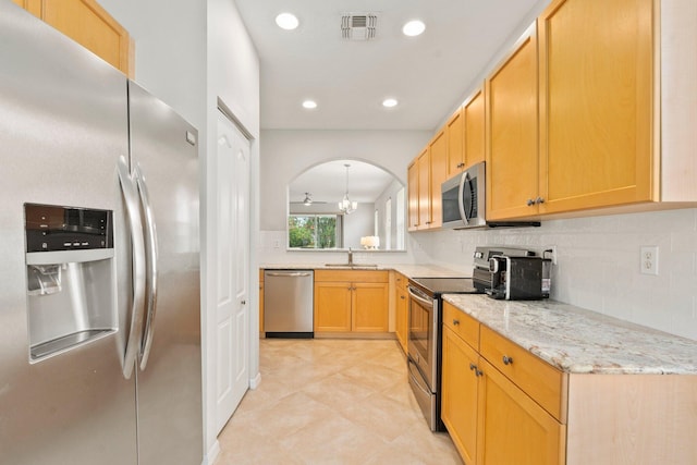 9943 SW Stonegate Dr, Port Saint Lucie, FL 34987 - kitchen featuring appliances with stainless steel finishes, tasteful backsplash, light stone countertops, light tile patterned floors, and recessed lighting