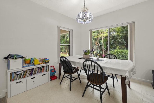 dining area featuring a chandelier and baseboards