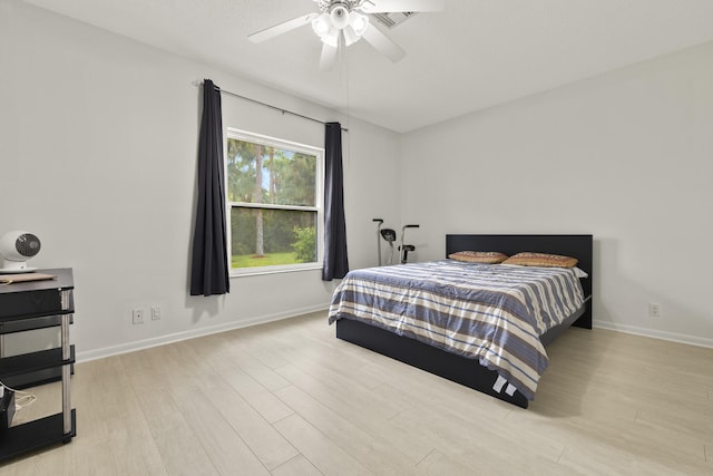 bedroom featuring baseboards, ceiling fan, and wood finished floors