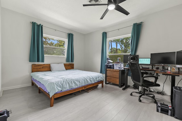 bedroom with wood finished floors, a ceiling fan, and multiple windows