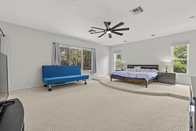 carpeted bedroom with baseboards, multiple windows, visible vents, and a textured ceiling