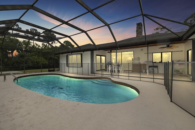 outdoor pool featuring ceiling fan, a patio area, and glass enclosure