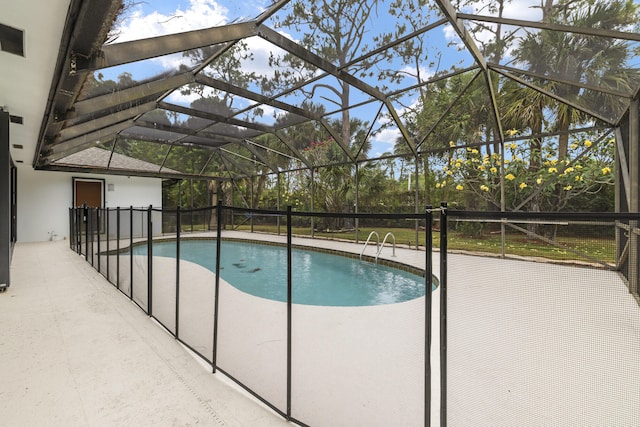 view of pool featuring a patio area, glass enclosure, and a fenced in pool
