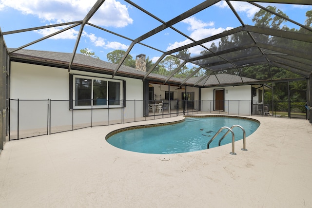 pool with a patio area, a ceiling fan, and glass enclosure