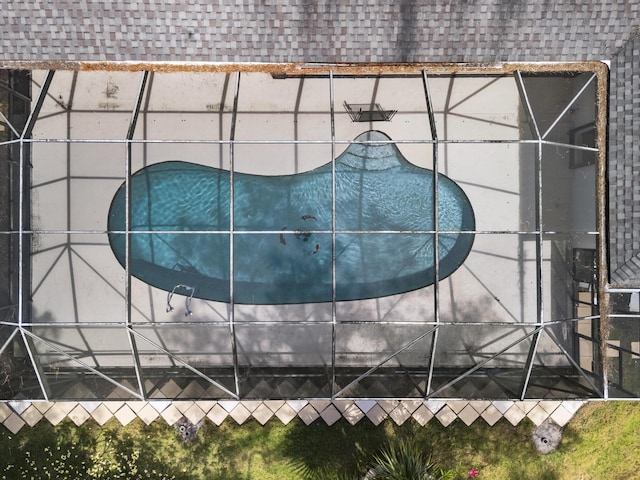 exterior view of roof with shingles and a swimming pool