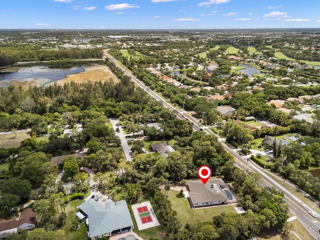 aerial view of property's location with a tree filled landscape and nearby suburban area