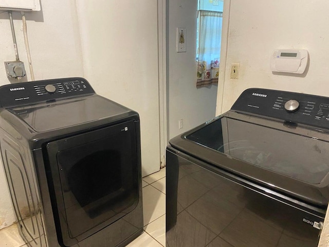 laundry area featuring laundry area, washing machine and dryer, and light tile patterned floors