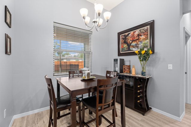 dining space featuring baseboards, a chandelier, and light wood-style flooring