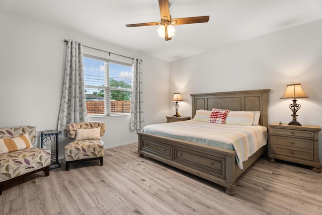 bedroom featuring baseboards, light wood-type flooring, and a ceiling fan