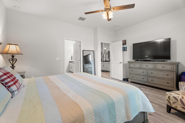 bedroom featuring ensuite bathroom, visible vents, wood finished floors, and ceiling fan