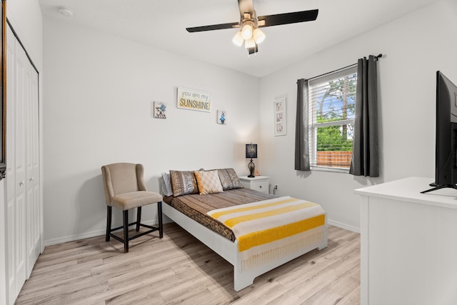 bedroom featuring a closet, a ceiling fan, wood finished floors, and baseboards