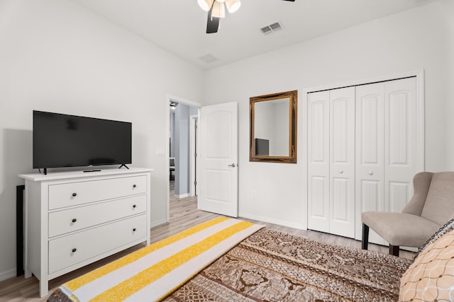 bedroom with light wood-style flooring, a ceiling fan, a closet, visible vents, and baseboards