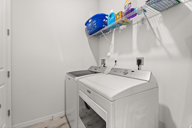 laundry room featuring light wood finished floors, laundry area, washer and clothes dryer, and baseboards