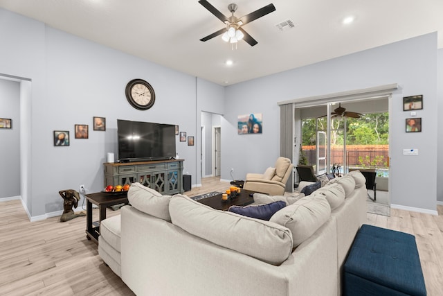 living area featuring baseboards, a ceiling fan, visible vents, and light wood-style floors