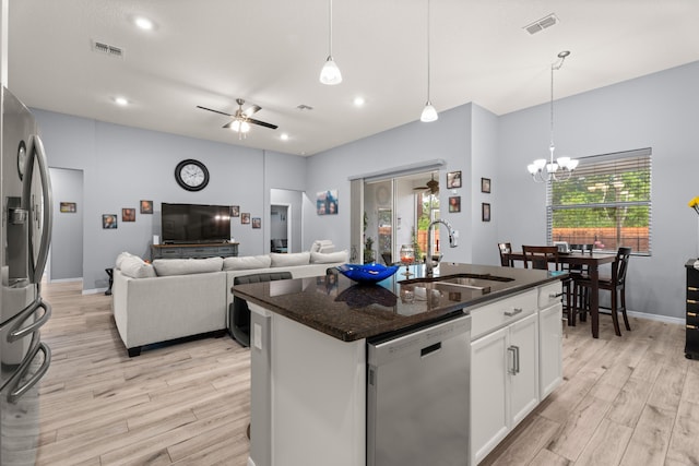 kitchen with stainless steel appliances, light wood-style flooring, a sink, and ceiling fan with notable chandelier