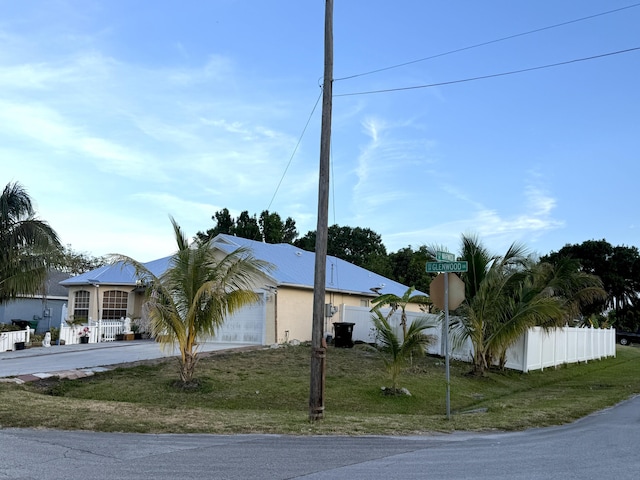 view of side of home featuring a yard, fence private yard, a garage, and driveway