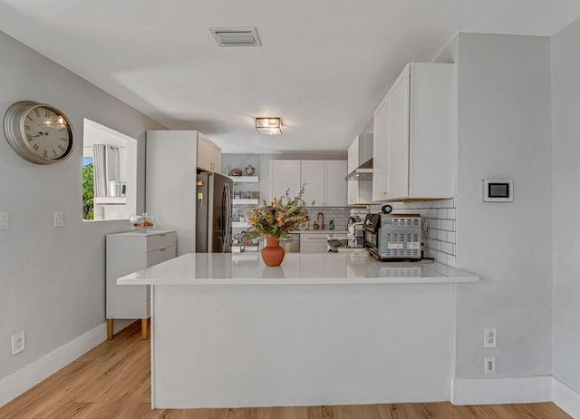 923 N H St, Lake Worth Beach, FL 33460 - kitchen featuring light countertops, decorative backsplash, freestanding refrigerator, and visible vents