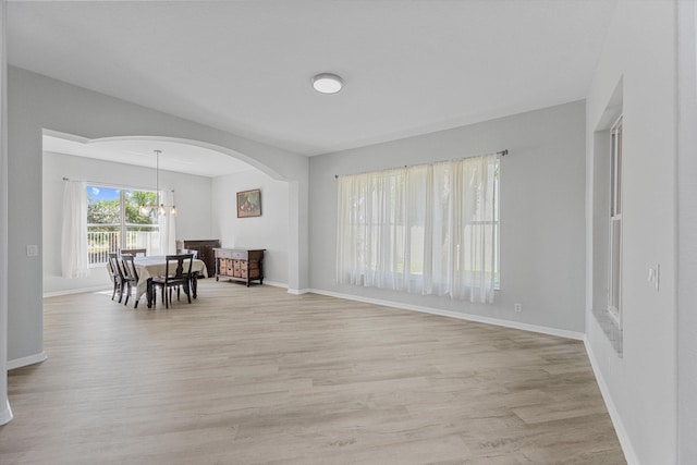 1317 Beacon Cir, Wellington, FL 33414 - living area with a chandelier, light wood finished floors, baseboards, and arched walkways