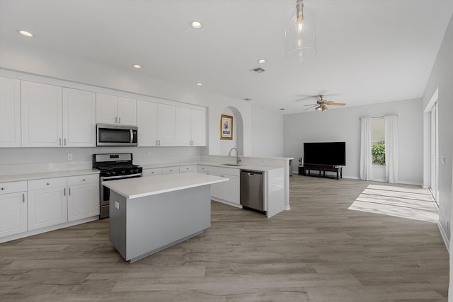 1317 Beacon Cir, Wellington, FL 33414 - kitchen featuring appliances with stainless steel finishes, a sink, open floor plan, a peninsula, and arched walkways