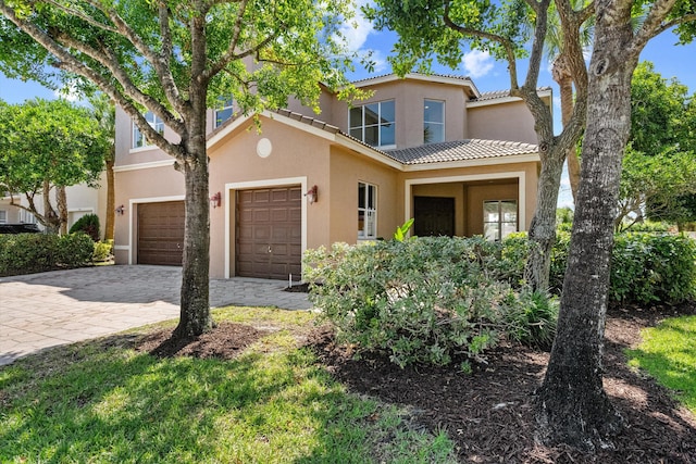 1317 Beacon Cir, Wellington, FL 33414 - view of front facade with stucco siding, a tiled roof, decorative driveway, and an attached garage