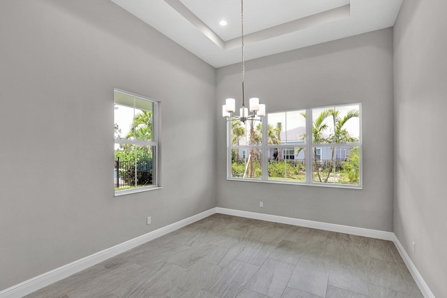 10148 Driftwood Way, Palm Beach Gardens, FL 33412 - spare room with a chandelier, baseboards, and a raised ceiling