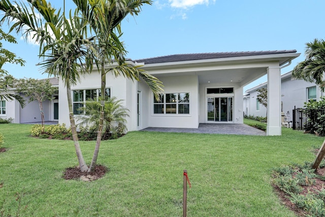 10148 Driftwood Way, Palm Beach Gardens, FL 33412 - rear view of property with a patio area, a lawn, and stucco siding