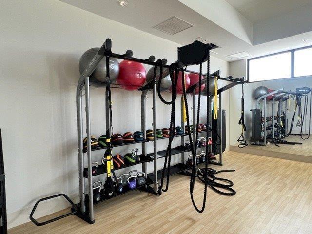 exercise room featuring wood finished floors and visible vents