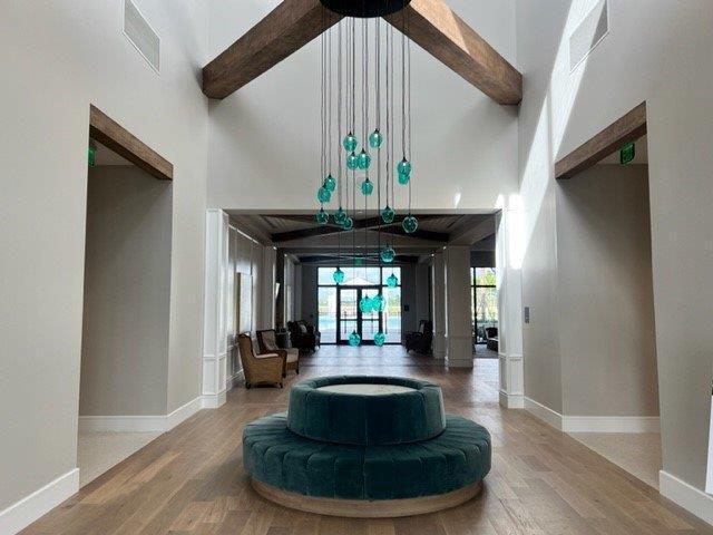 10148 Driftwood Way, Palm Beach Gardens, FL 33412 - living area with a towering ceiling, wood finished floors, baseboards, and beam ceiling