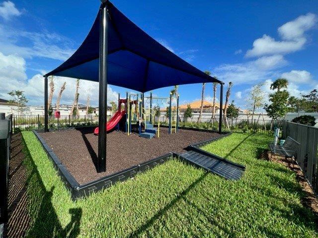 communal playground featuring fence and a yard