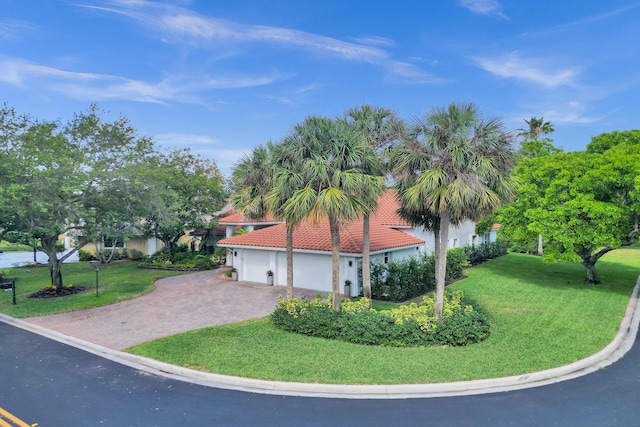 view of side of home featuring a tiled roof, stucco siding, a yard, and driveway