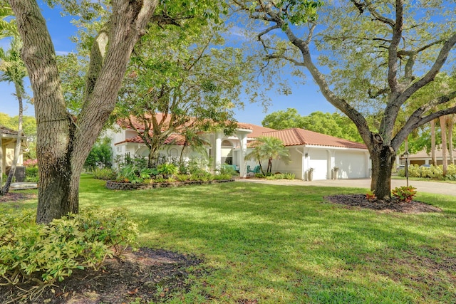 view of front facade featuring stucco siding, a tiled roof, a garage, a front lawn, and concrete driveway
