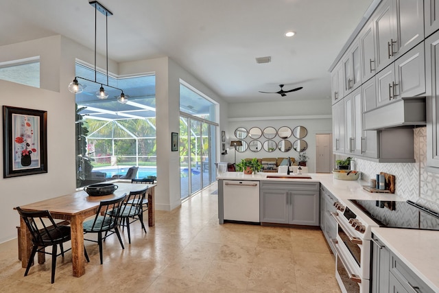 kitchen featuring white appliances, ceiling fan, custom exhaust hood, a sink, and gray cabinets