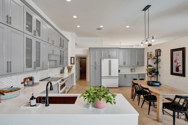 kitchen with white appliances, gray cabinets, backsplash, recessed lighting, and light countertops