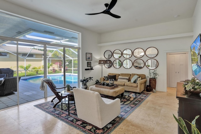 living area with a sunroom and a ceiling fan
