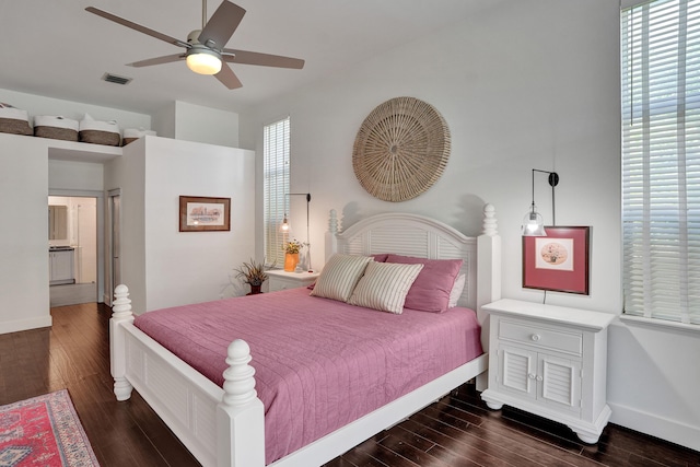 bedroom featuring dark wood-type flooring, baseboards, and multiple windows