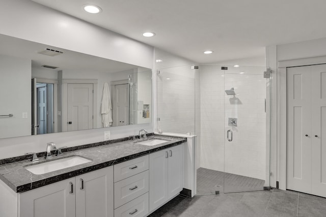 full bath with a stall shower, double vanity, tile patterned floors, and recessed lighting