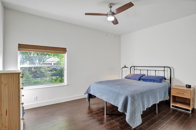 bedroom with dark wood-style flooring, baseboards, and a ceiling fan