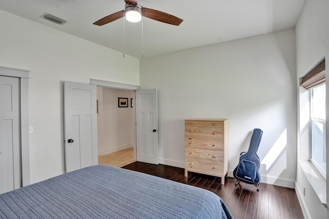 bedroom featuring wood-type flooring, baseboards, a ceiling fan, and a high ceiling