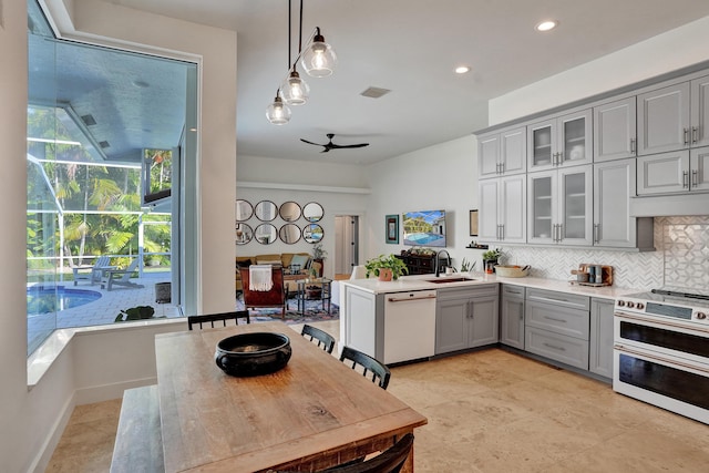 kitchen with gray cabinets, white appliances, tasteful backsplash, a sink, and glass insert cabinets