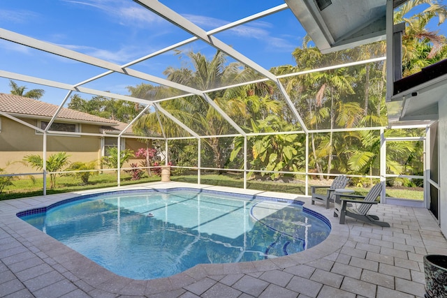 outdoor pool featuring a patio area and glass enclosure