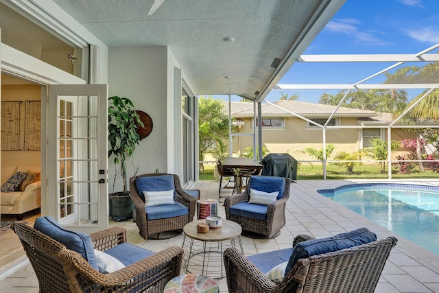 outdoor pool featuring a patio, an outdoor living space, grilling area, french doors, and glass enclosure